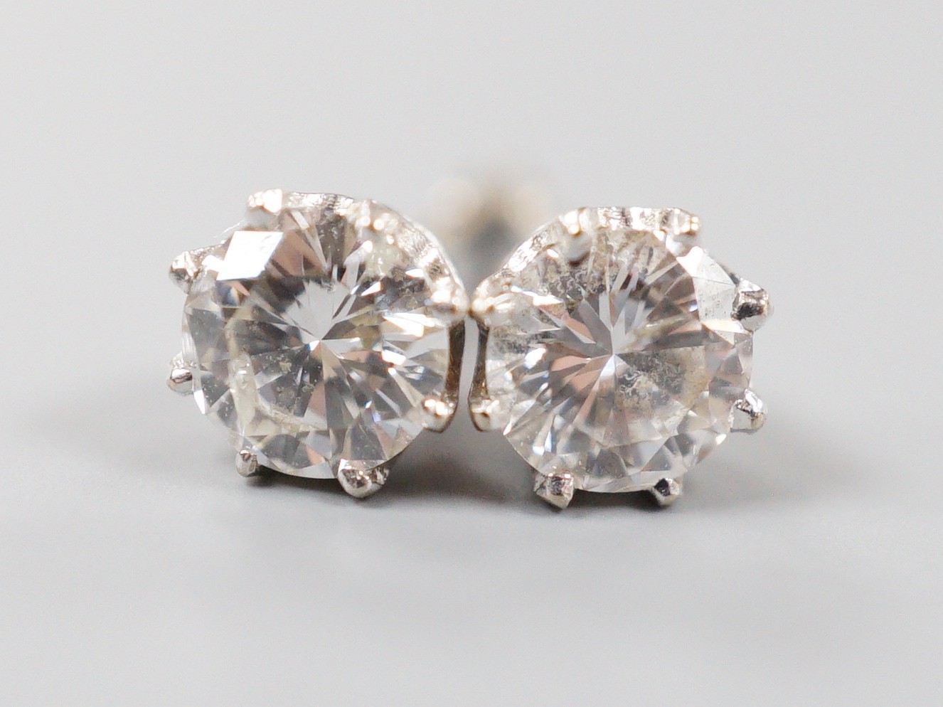A modern pair of 18k white metal and solitaire diamond set ear studs (butterflies differ), gross weight 1.4 grams